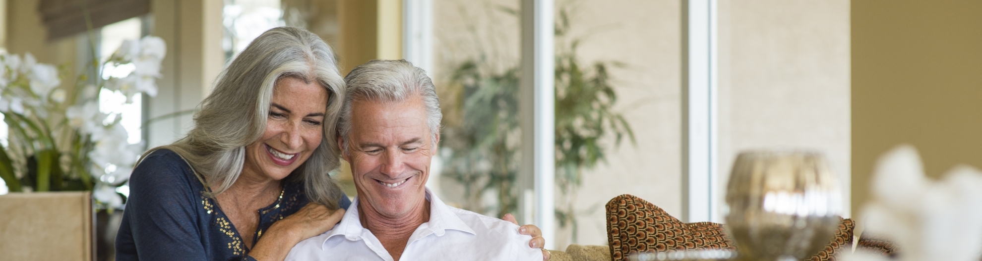 Older Caucasian couple using digital tablet on sofa